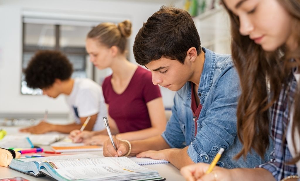adolescentes estudam focados em ambiente escolar.