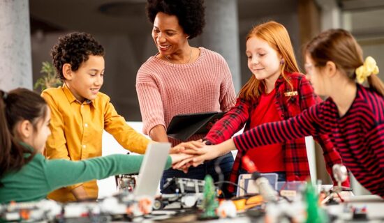 Professora em laboratório de robótica aplicando a cultura Maker com os seus alunos.