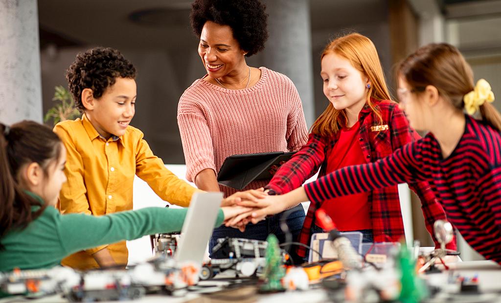 Professora em laboratório de robótica aplicando a cultura Maker com os seus alunos.