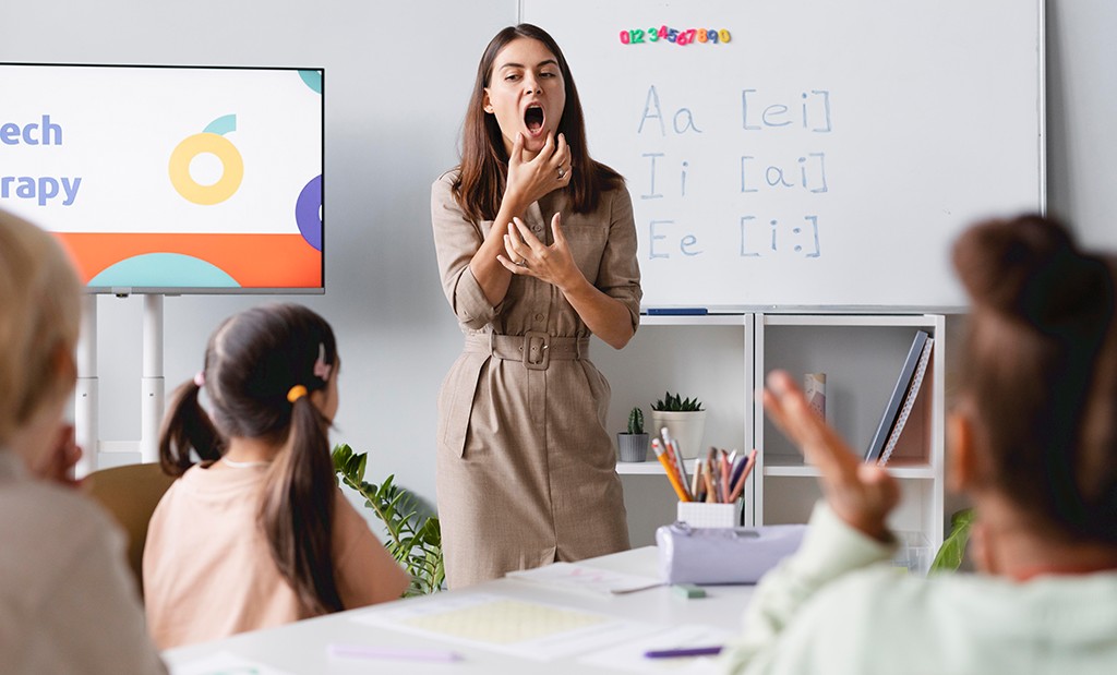 Professora ensinando técnicas de Speaking para crianças em sala de aula.