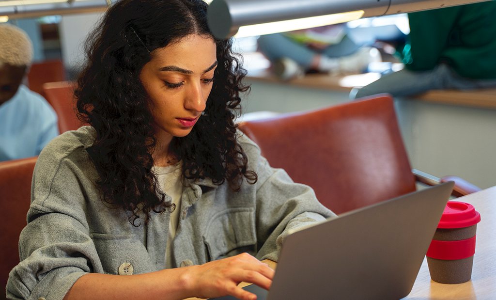 Menina estudante do ensino médio em um café usando o computador para estudar inglês com tradutor automático.