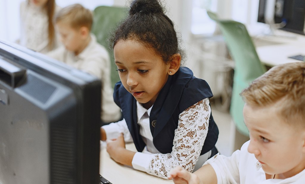 Alunos do ensino fundamental usando tradutor automático para estudar inglês na sala de informática da escola.